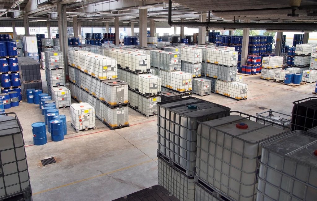 Interior de armazém logístico com paletes e contentores