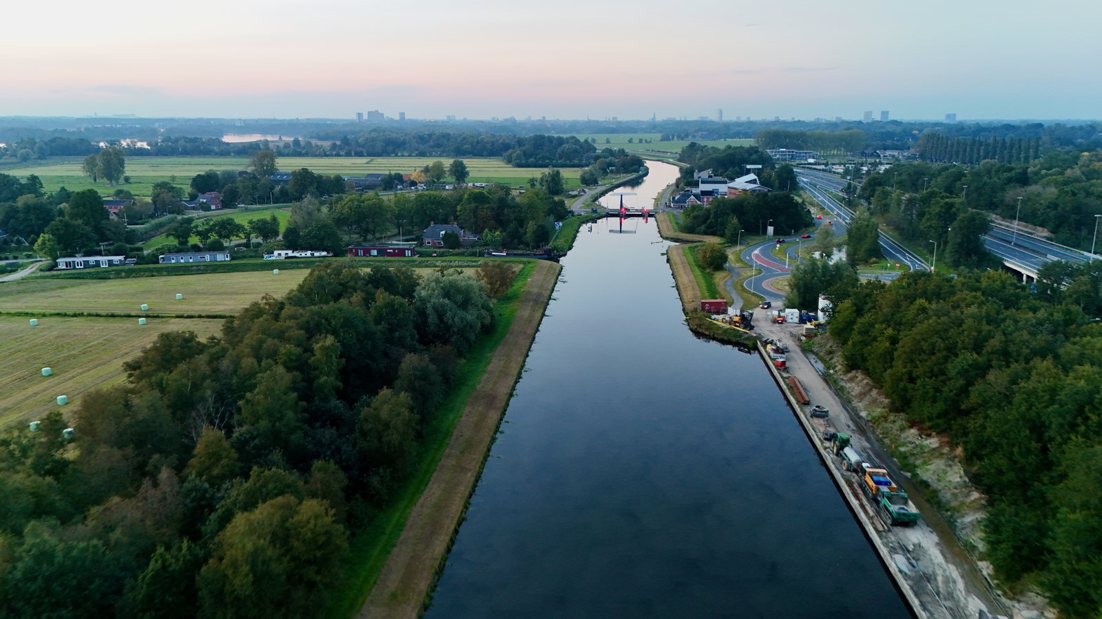 Rio cercado por vegetação em área urbana, vista aérea